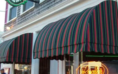 A store front with awnings and signs on the windows.