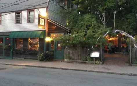 A restaurant with many tables and chairs outside