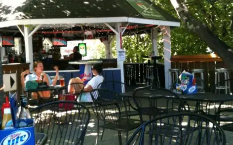 A group of people sitting at tables outside.