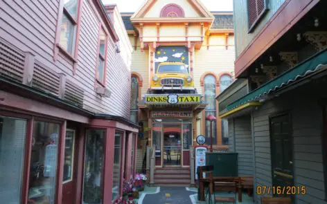 A street with many buildings and stairs leading to the entrance.