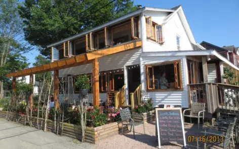 A white building with a wooden roof and a porch.