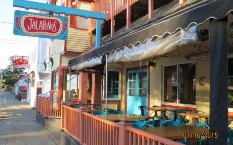 A restaurant with tables and chairs outside of it.