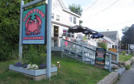 A sign for the lobster house in front of a building.