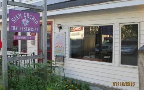 A restaurant with a purple sign on the front of it.