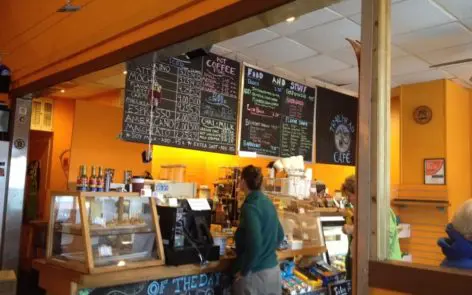 A person standing at the counter of a cafe.