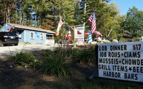 A sign in front of some trees and buildings