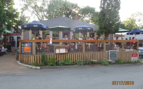 A group of people sitting at tables under umbrellas.