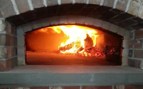 A fire in an oven with smoke coming out of it.