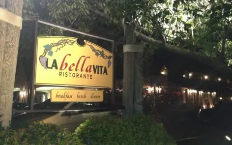 A sign for la bella vita ristorante on the side of a road.