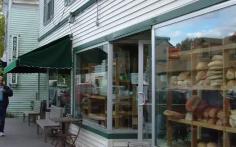 A store front with tables and chairs outside it