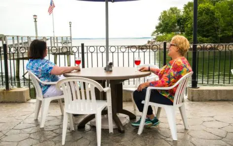 Two women sitting at a table with wine glasses.