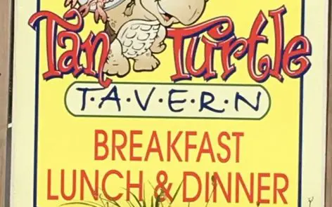 A sign for an turt 's tavern breakfast lunch and dinner.