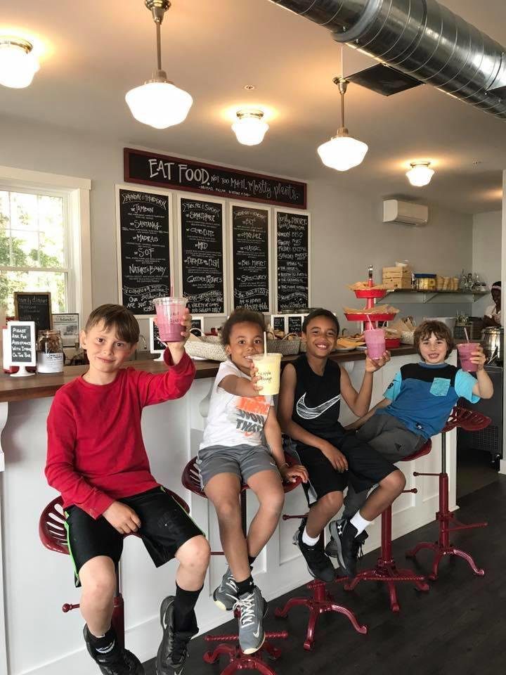 A group of kids sitting in front of a counter.