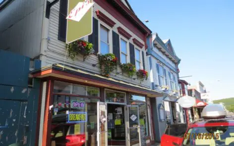 A store front with many windows and flowers on the outside.