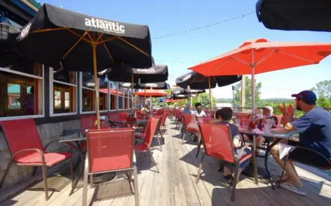 A restaurant with tables and chairs covered in umbrellas.