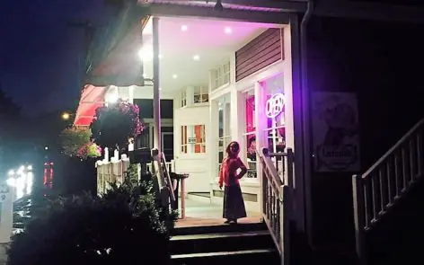 A little girl standing in front of a house at night.