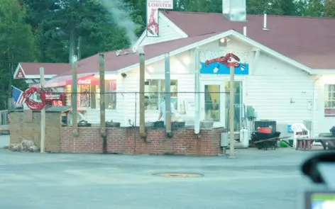 A white building with red roof and blue door.