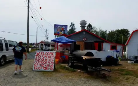 A street scene with a bbq and a sign.