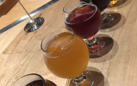 A table with four glasses of different drinks.