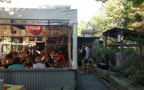 A group of people sitting at tables outside.