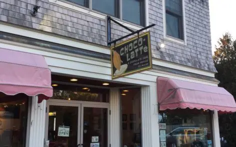 A store front with two pink awnings and a sign