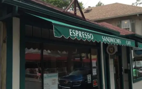 A green awning over the entrance to an espresso shop.